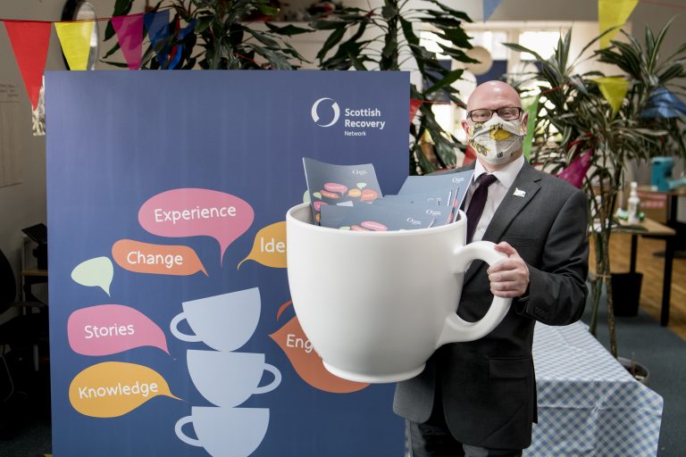 Photo of Minister for Mental Wellbeing and Social Care with a giant teacup.