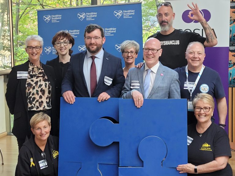 Attendees of the launch of the new Suicide Prevention Strategy posing with a giant jigsaw.