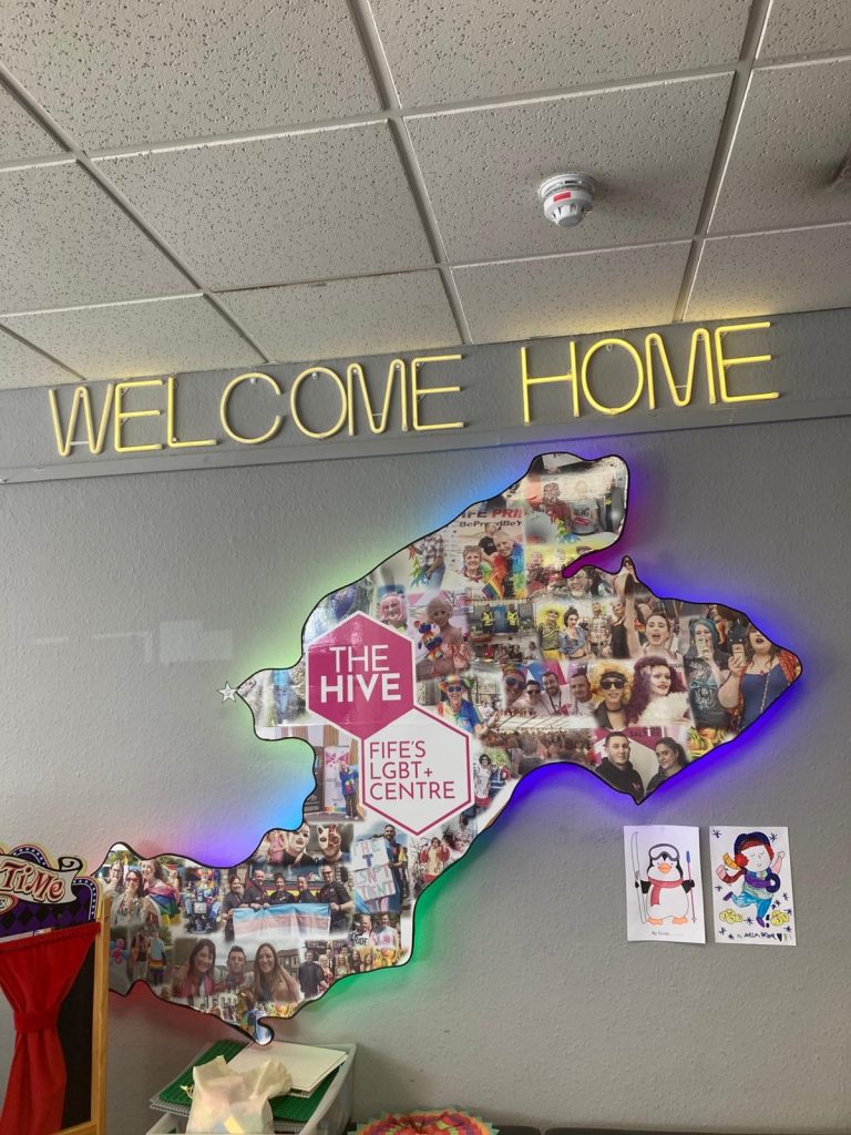 A map on the wall with the words Welcome Home lit up above it.